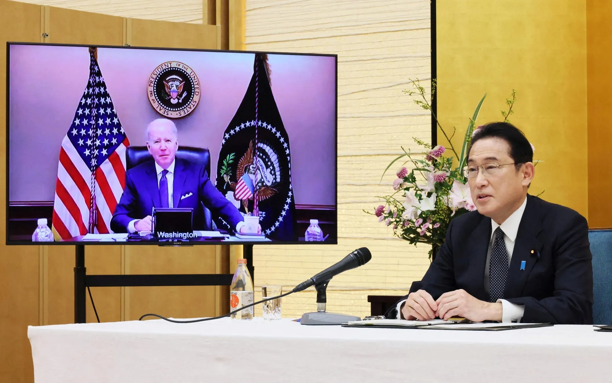 A world leader meeting face-to-face on a large screen